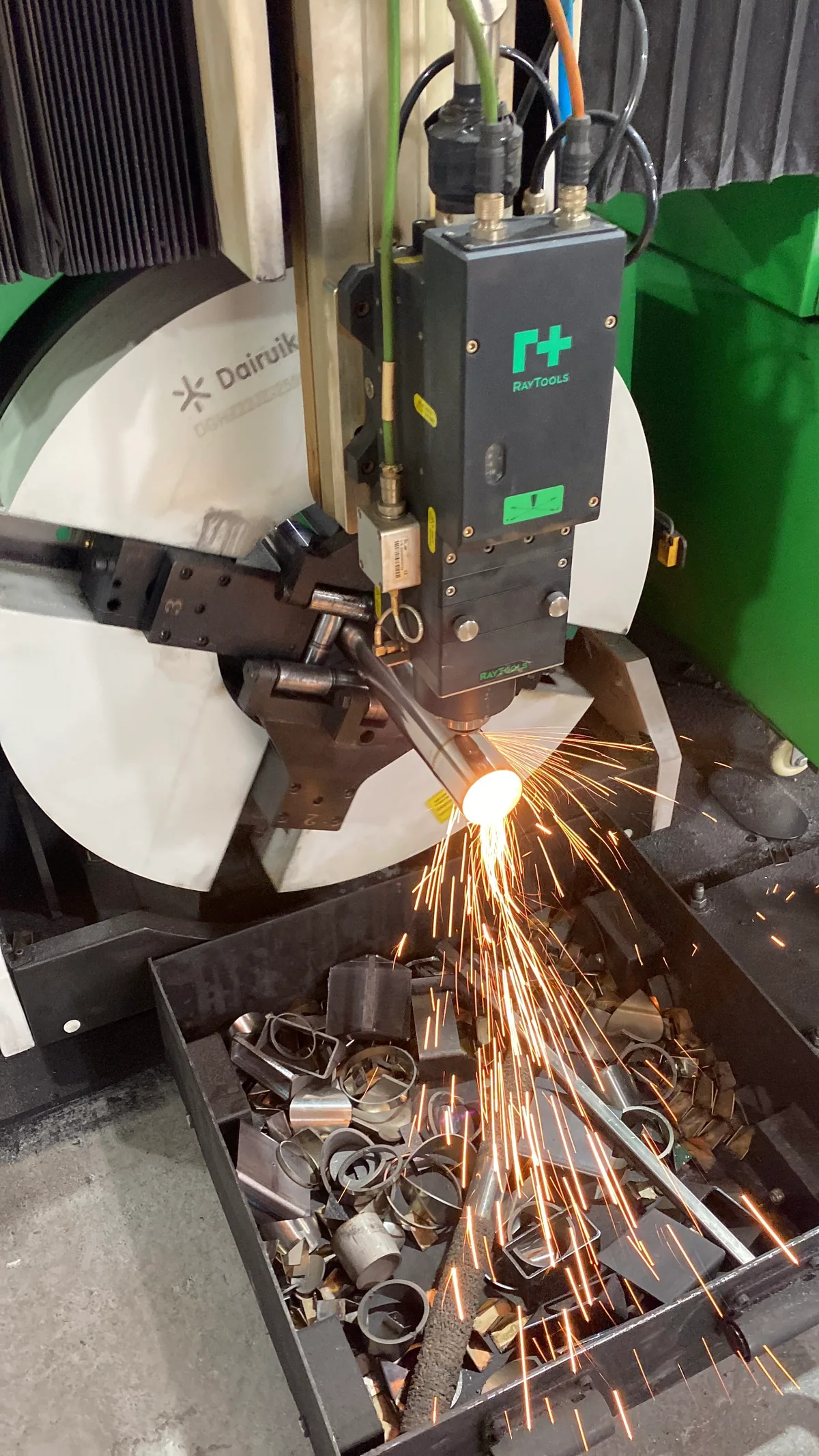 Máquina realizando corte a laser em tubo metálico